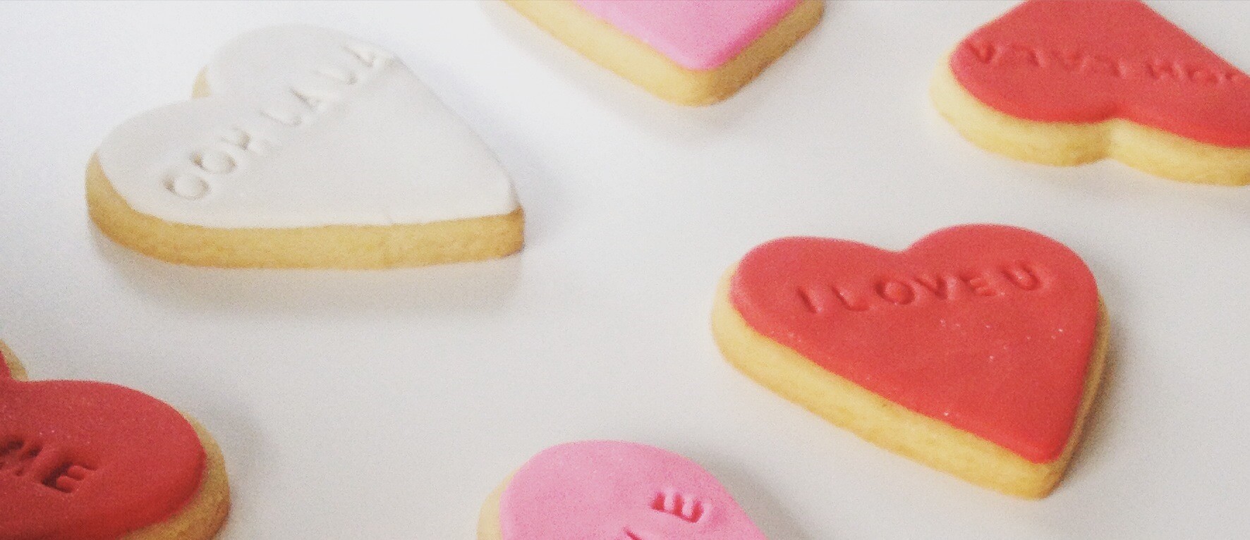 Romantic biscuits for Valentine's Day from Chez Nous Corporate Catering. Love heart shapes with romantic words on it.